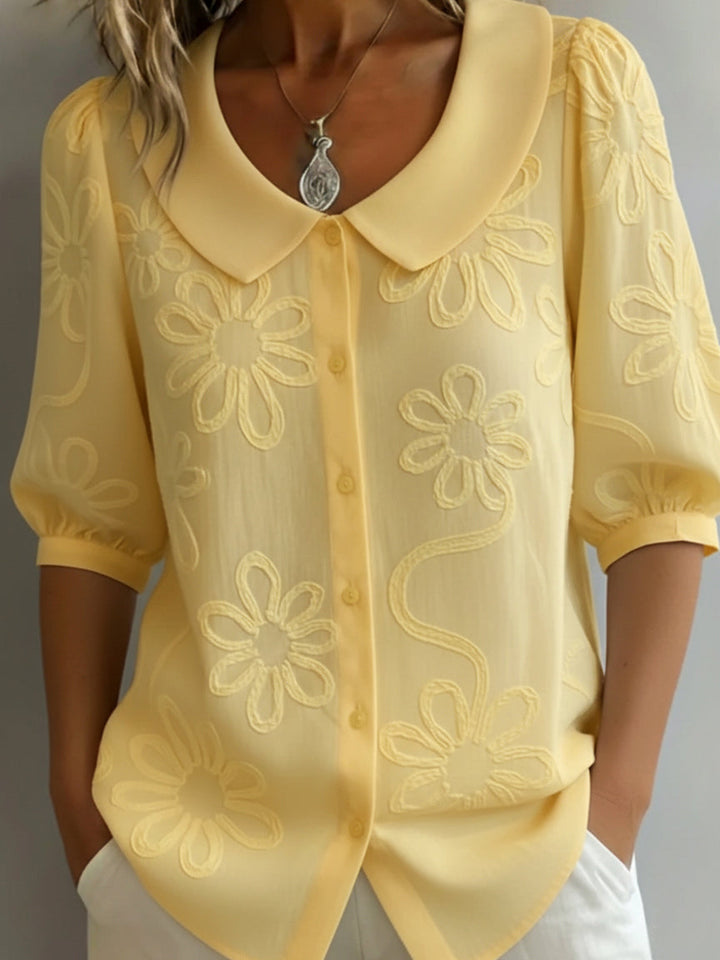 Damebluse med blomsterbroderier og Peter Pan-krage