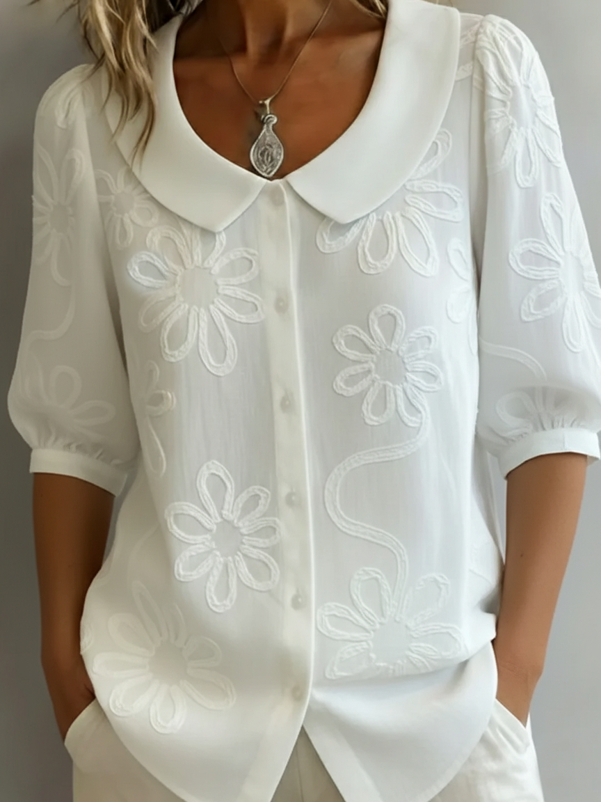 Damebluse med blomsterbroderier og Peter Pan-krage